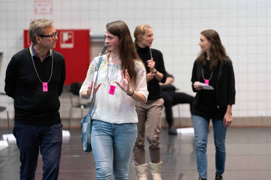 Participants walking in a large circle in conversation, project The Polarity Party. Photo: Dirk Rose