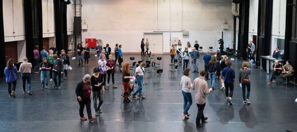 Participants walking in a large circle in conversation, project The Polarity Party. Photo: Dirk Rose